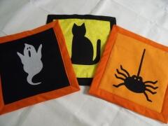 These are samples of three halloween potholders/hotpads designed by Carol Murphy, Sept. 2009; she used an 8 1/2" square block; insul-bright insulated batting; and a yard of bias tape, plus the adorable halloween appliques
